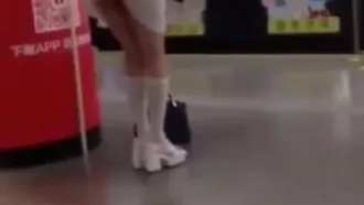 Una chica con falda corta tira abiertamente de un vibrador en el andén de la estación....