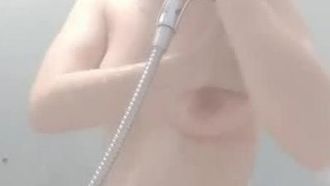 Une belle jeune femme à la peau claire se touche sous la douche, exhibant sa chatte clairsemée et assez rose. Elle a l'air très attirante et tentante.