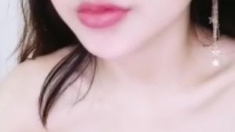 Una ragazza carina e di bell'aspetto indossa un vestito blu sexy, usa le dita per allacciarsi la figa con un vibratore e una bacchetta di vetro e si masturba per fare del succo bianco.