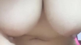 Ein Mädchen mit einem prallen Körper und großen Brüsten ist nackt und berührt sich mit den Fingern. Es ist sehr verlockend .