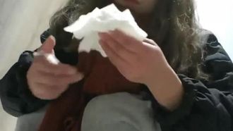 ショッピングモールの女子トイレで赤い携帯電話を持つ美しい若い女性のパノラマの率直なショット