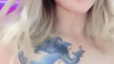 A very sultry internet celebrity anchor shows off her body in a seductive manner and has a very social tattoo on her arm.