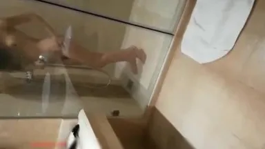 A beautiful woman takes a shower without closing the door and is peeped by a male waiter while having sex on the balcony