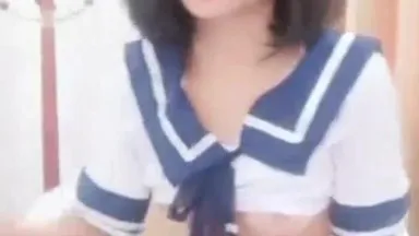 The girl touches her breasts, masturbates her pussy, and shows off her student uniform with a vibrator and a plug in her pussy, with her butt raised