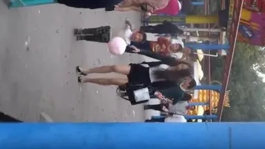 Photographier en secret une belle jeune femme emmenant son enfant dans un parc d'attractions. Dans l'attente du moment où elle écartera les jambes.