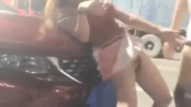 Una chica con gafas de sol tiene sexo al costado de la carretera a altas horas de la noche, abrazándola y follándola por detrás sobre el capó, sin aliento a altas horas de la noche.