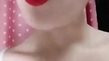 Симпатичная девушка со светлой кожей и красными губами раздвигает обнаженные ноги и мастурбирует вживую с вставленным в ее киску вибратором.