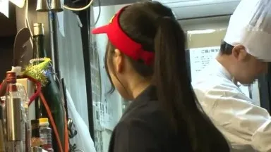 Un employé à la peau claire travaillant à temps partiel dans un magasin de curry rougit en servant les clients.