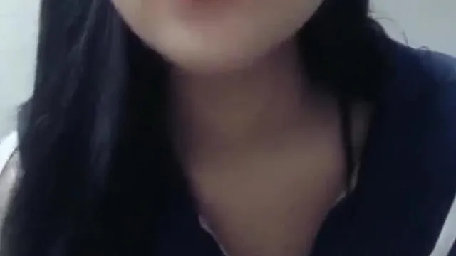 Una chica seductora con uniforme de estudiante se masturba y gime mientras una chica guapa se cambia de ropa y usa accesorios en la cama
