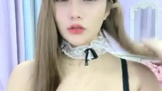 Hangzhou Barbie, une jolie et douce célébrité d'Internet, lève les pieds sur la chaise avec des bas résille blancs et vibre.