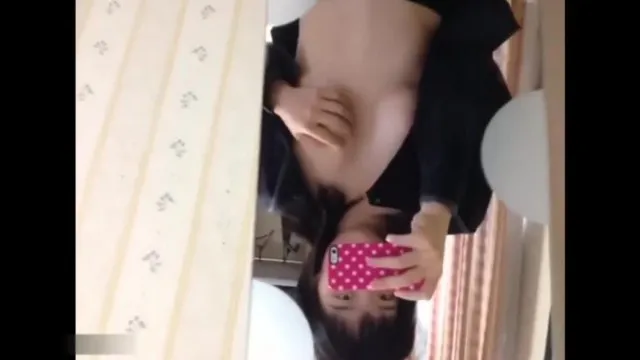 A jovem inocente mostra o rosto e se masturba na frente do espelho em casa e tira uma selfie