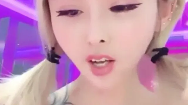 Una presentadora de celebridades de Internet muy sensual muestra su transmisión en vivo en su teléfono móvil. Tiene un bonito cuerpo y tatuajes en los brazos, lo cual es muy sociable.